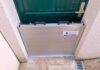 Barrière anti-inondation en aluminium installée devant une porte d'entrée de maison