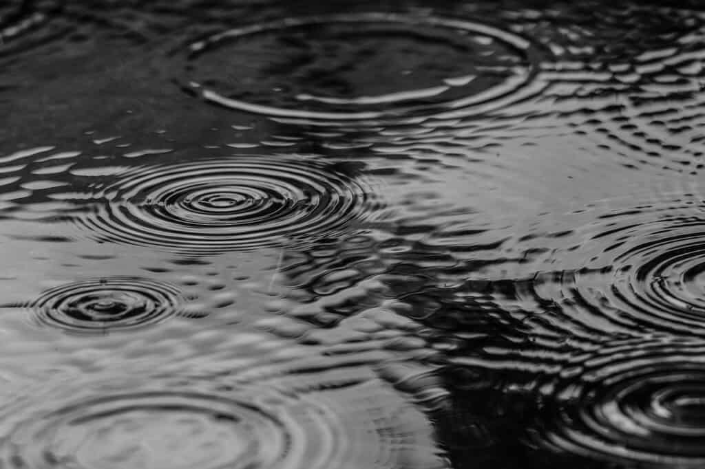 Goutte de pluie qui tombe dans une flaque inondée