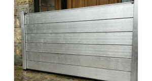 Batardeau en aluminium installé devant une porte d’entrée sur un perron en pierre mouillée pour protéger la maison des inondations