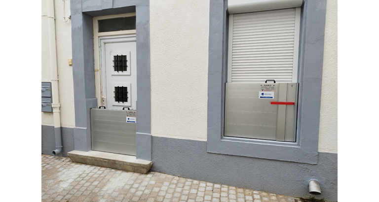 Façade de maison équipée de batardeaux autobloquants en aluminium devant la porte d’entrée et une fenêtre pour se protéger des inondations