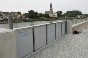 Batardeau automatique renforcé au Kevlar installé en bord de rivière pour une protection anti-crue autonome.