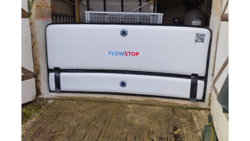 Batardeau gonflable blanc Flowstop positionné dans l’ouverture d’un garage pour former une barrière anti inondation temporaire