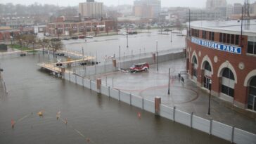 Barrière anti-inondation industrielle protégeant un site commercial contre une crue dans une zone urbaine.