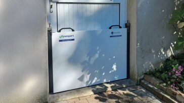 Batardeau monobloc rigide installé devant une porte pour une protection anti-inondation rapide et robuste.
